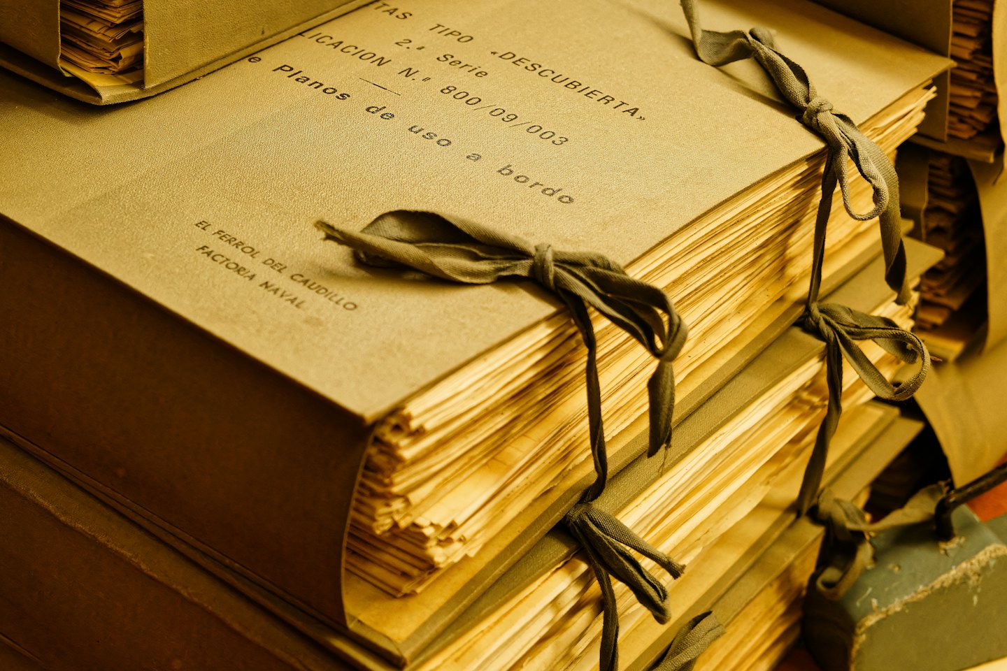 Stacked old documents tied with dark ribbon.